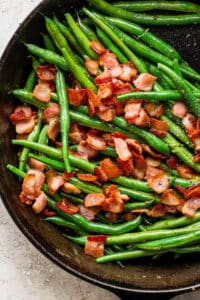 Green beans and bacon in a cast iron skillet.