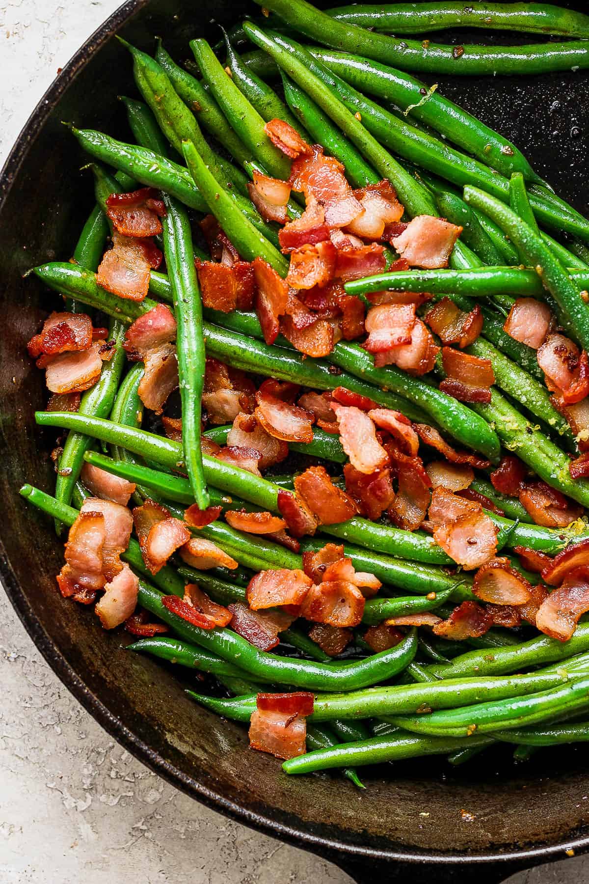 Green beans with bacon in a skillet.