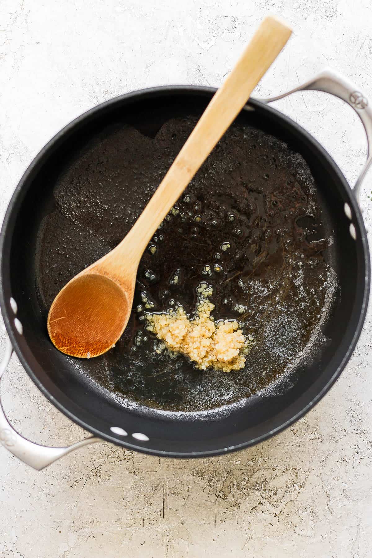 Garlic sautéing in melted butter in a large pot.