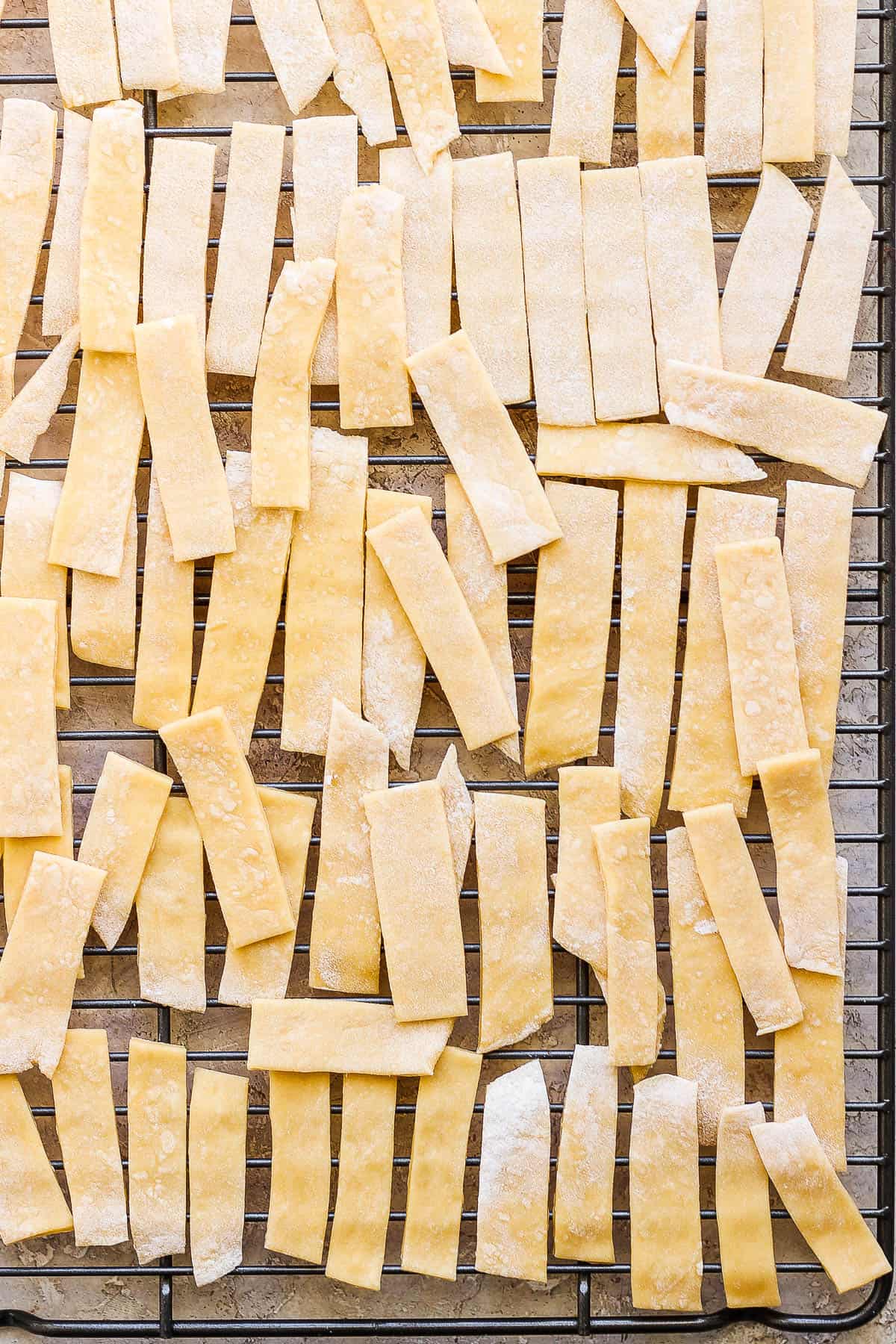 Egg noodles drying on a drying rack.