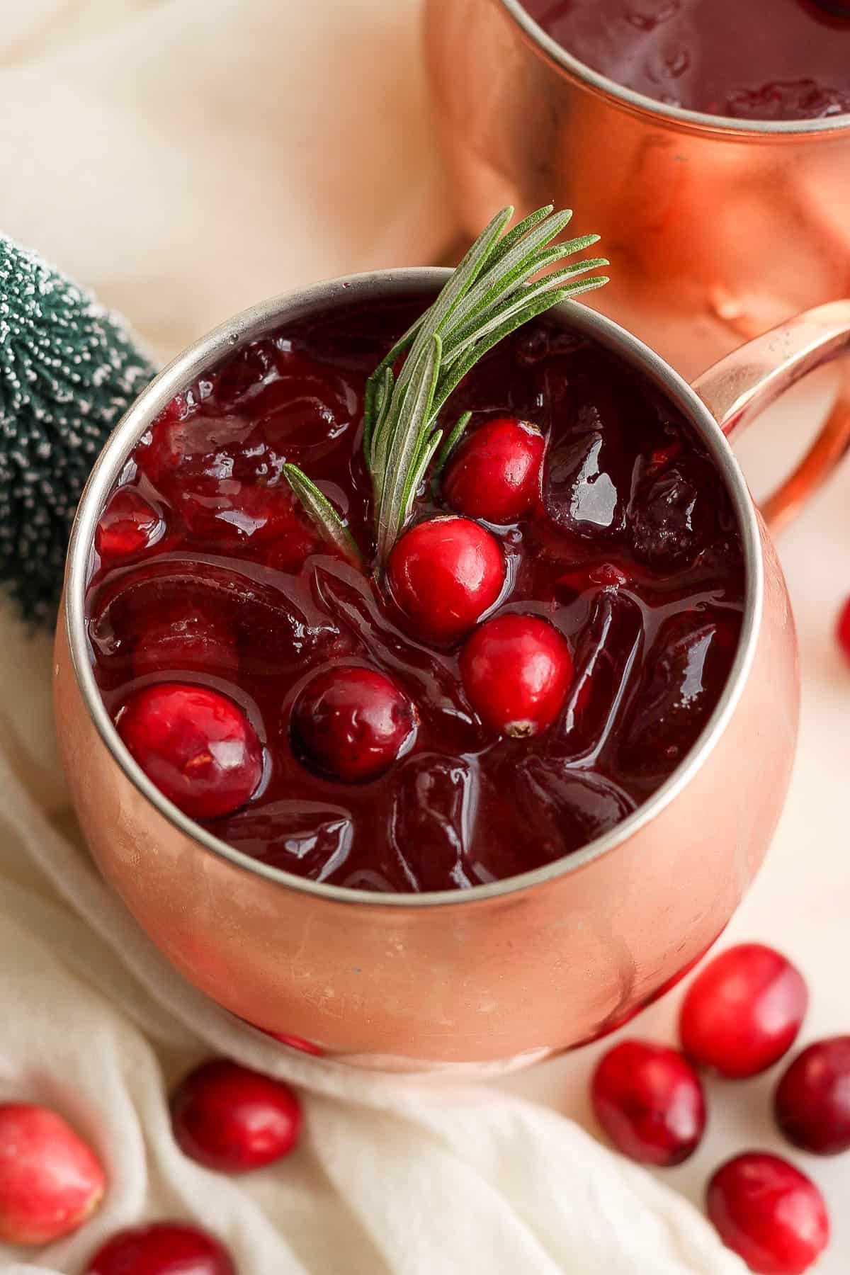 A cranberry moscow mule cocktail in a mule mug.