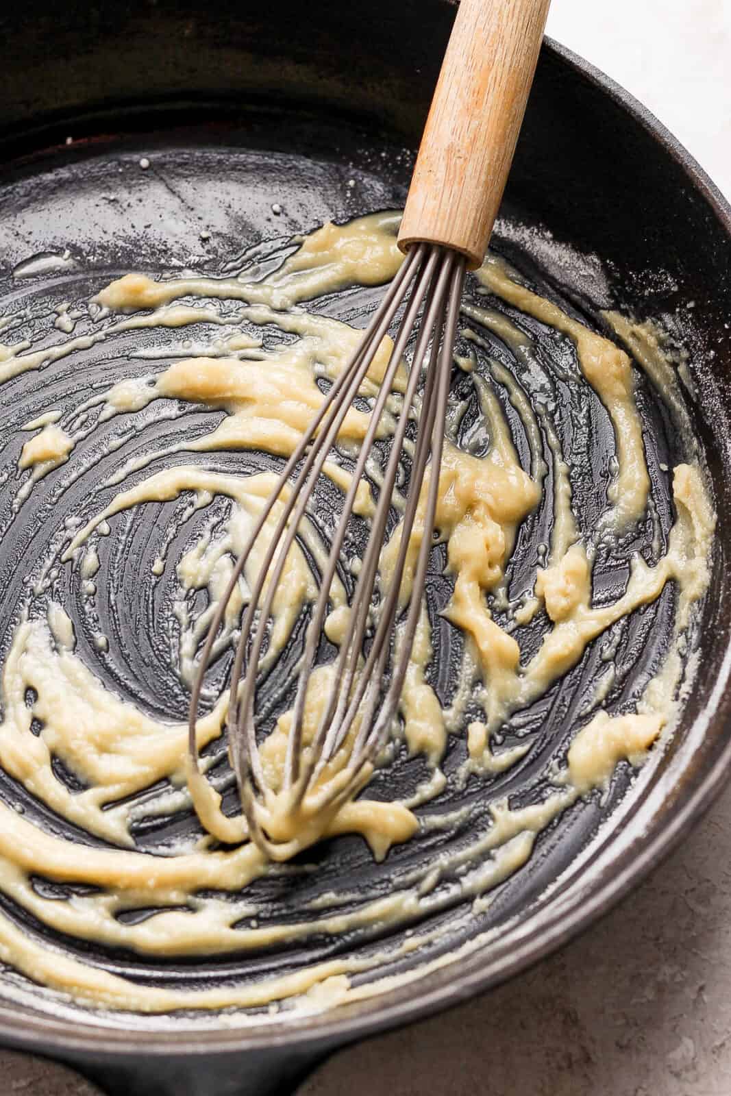 Drippings being whisked in to the roux to create the gravy.