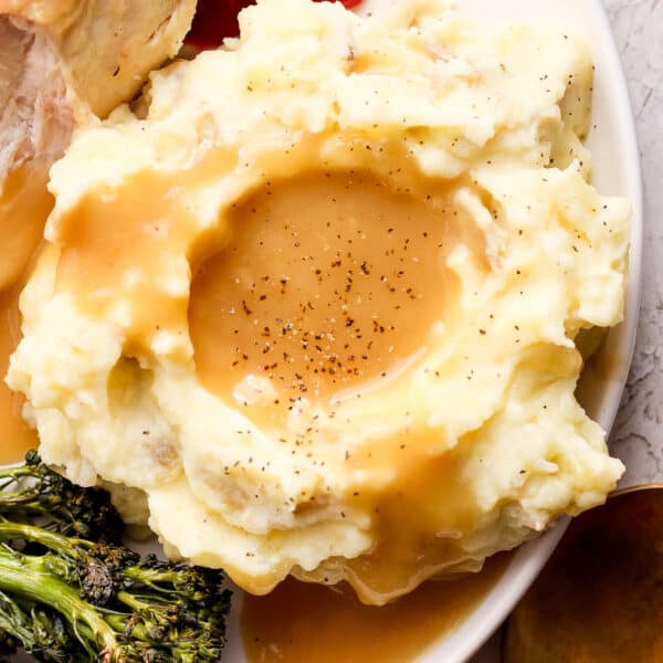 Top down shot of a pile of mashed potatoes covered in make ahead gravy.