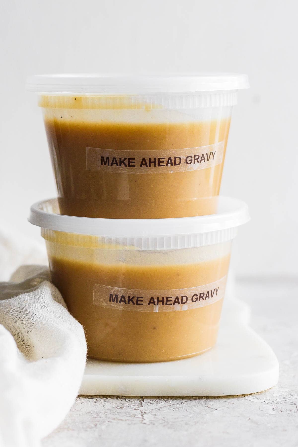 Two freezer safe containers of make ahead gravy.