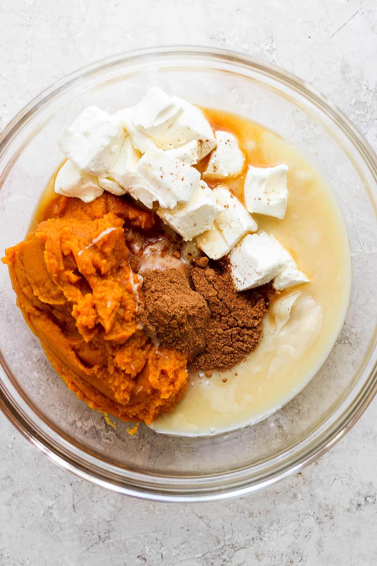 Ingredients for this pumpkin pie recipe in a large glass bowl.