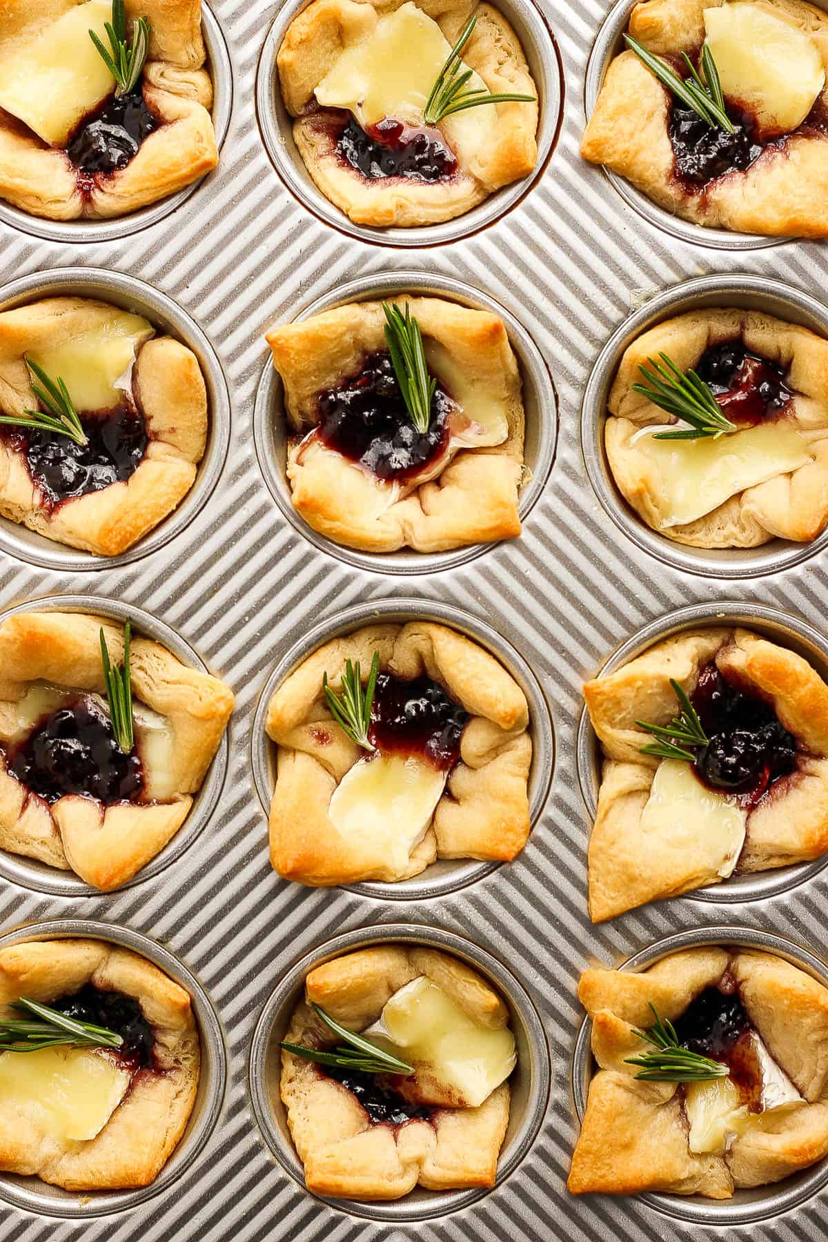 Baked brie bites in a muffin tin.