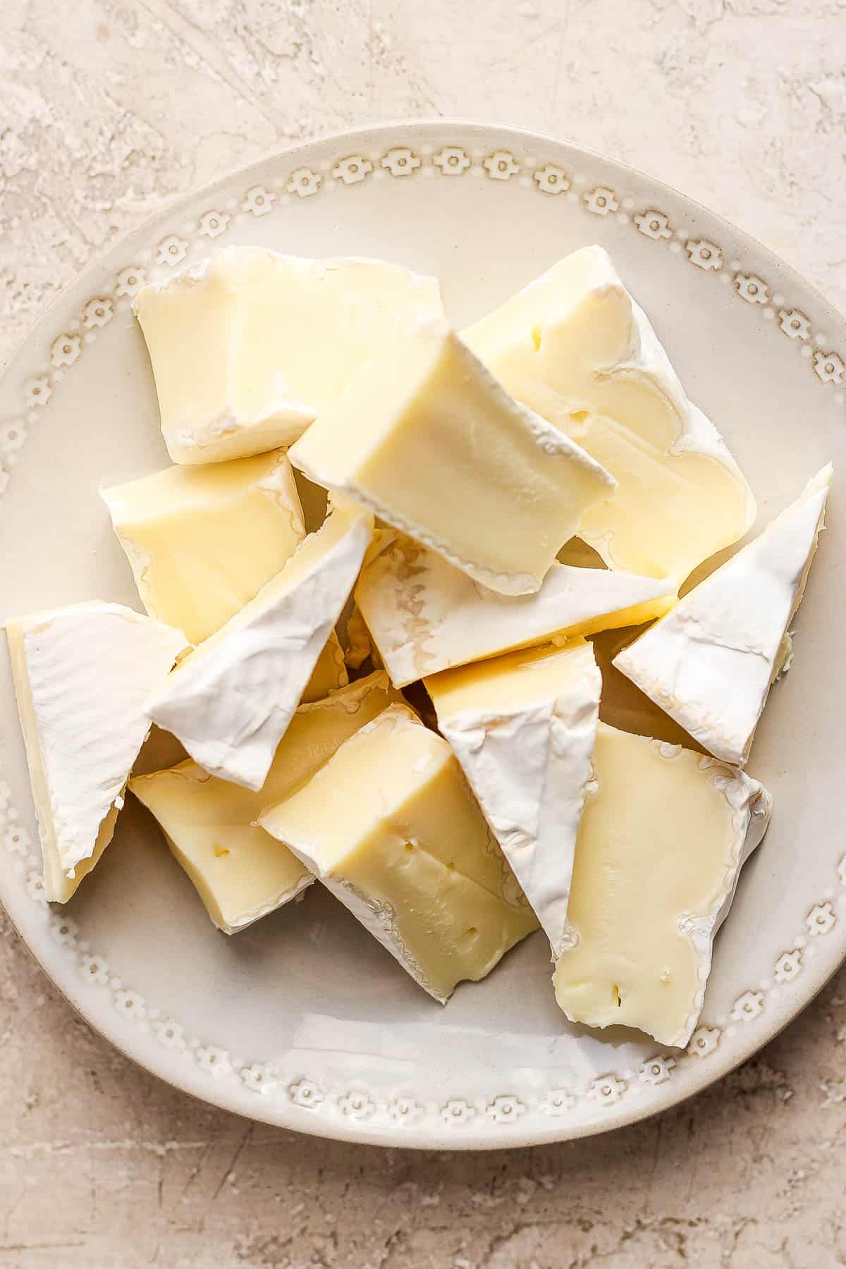12 wedges of brie cheese on a plate.