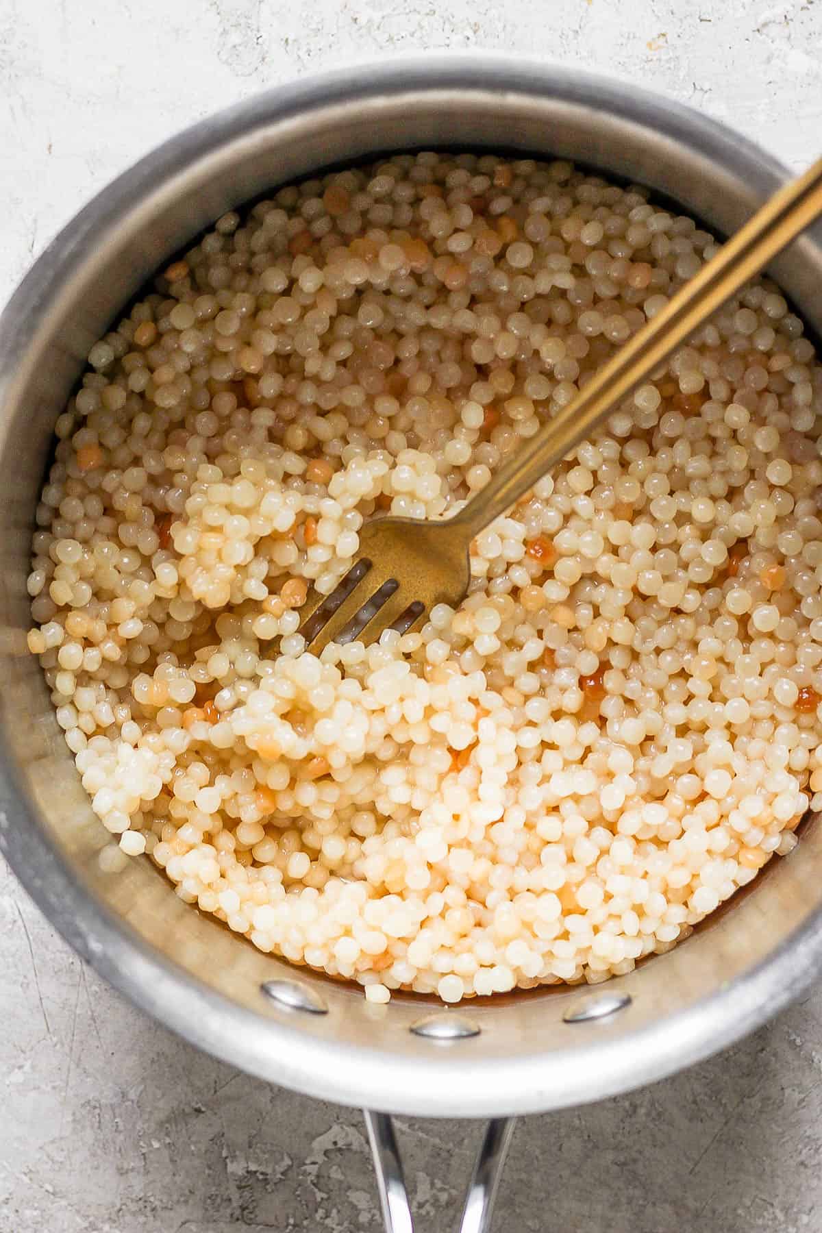Cooked pearl couscous in a pot before being added to a Greek couscous salad.