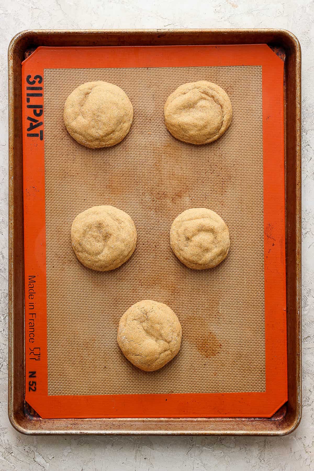Five cookies on baking sheet.