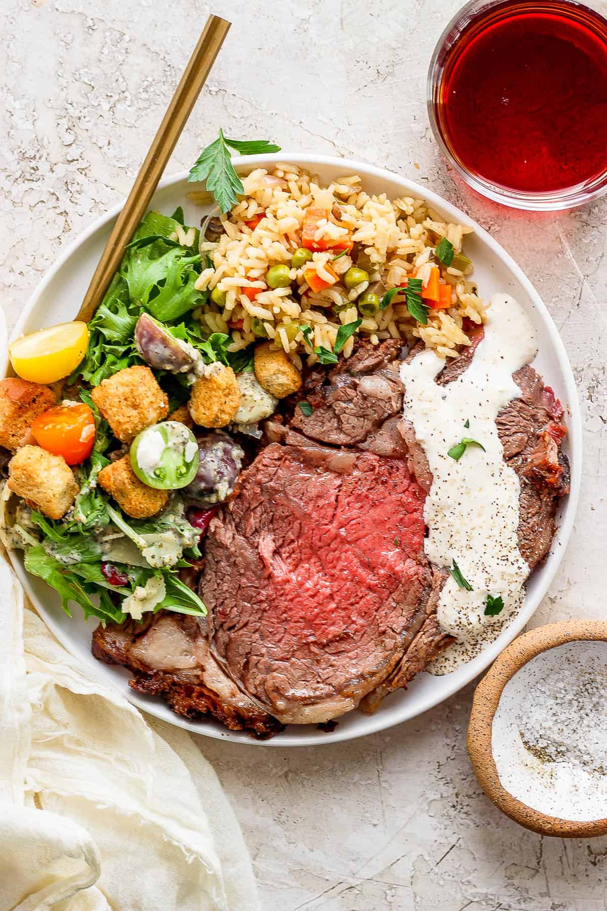 The perfect slice of grilled prime rib with horseradish sauce and a house salad and rice pilaf on the side.