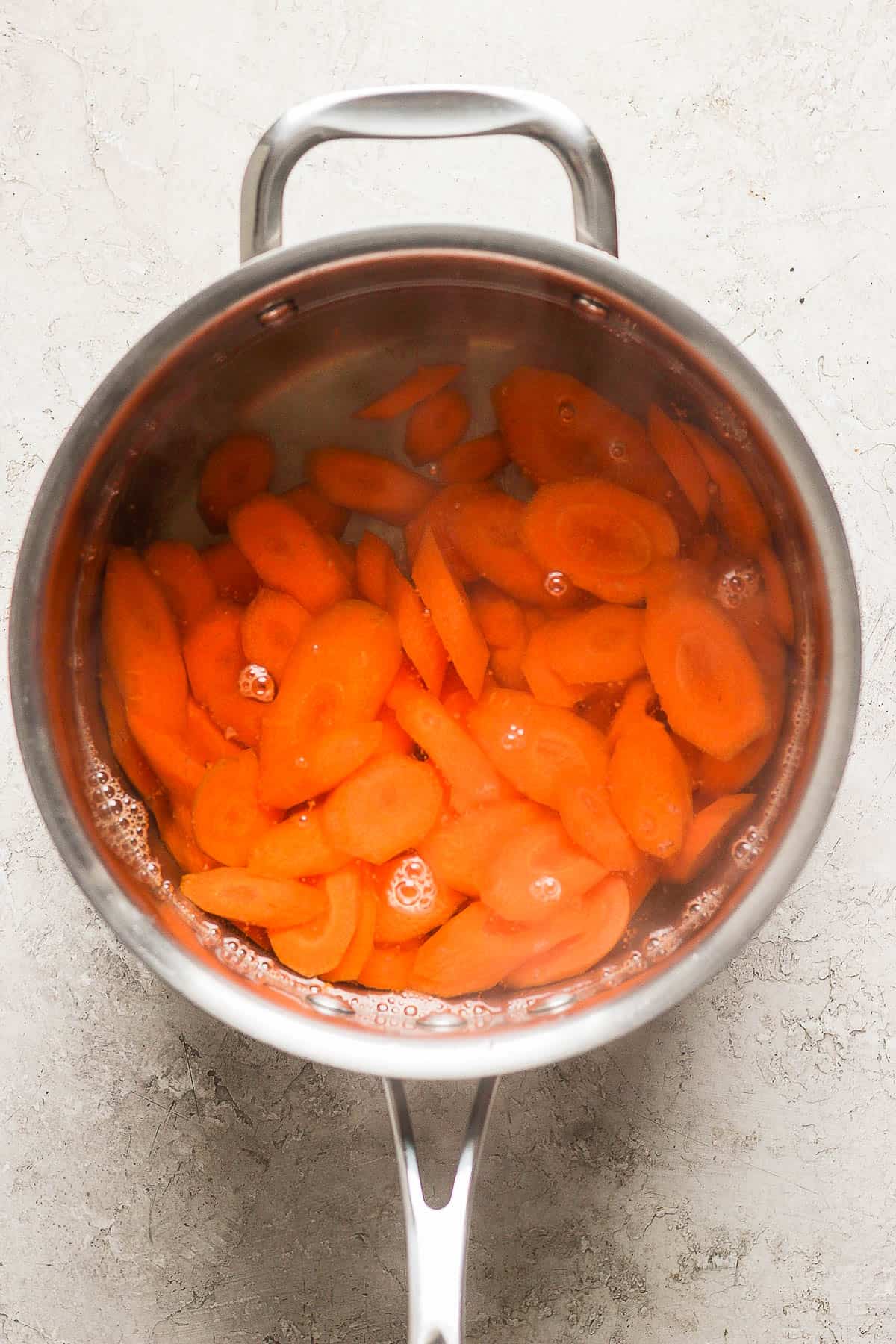 Carrot coins in a saucepan of boiling water.