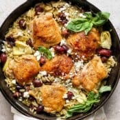 Top down shot of a kalamata lemon chicken orzo skillet with feta cheese and fresh basil on top.
