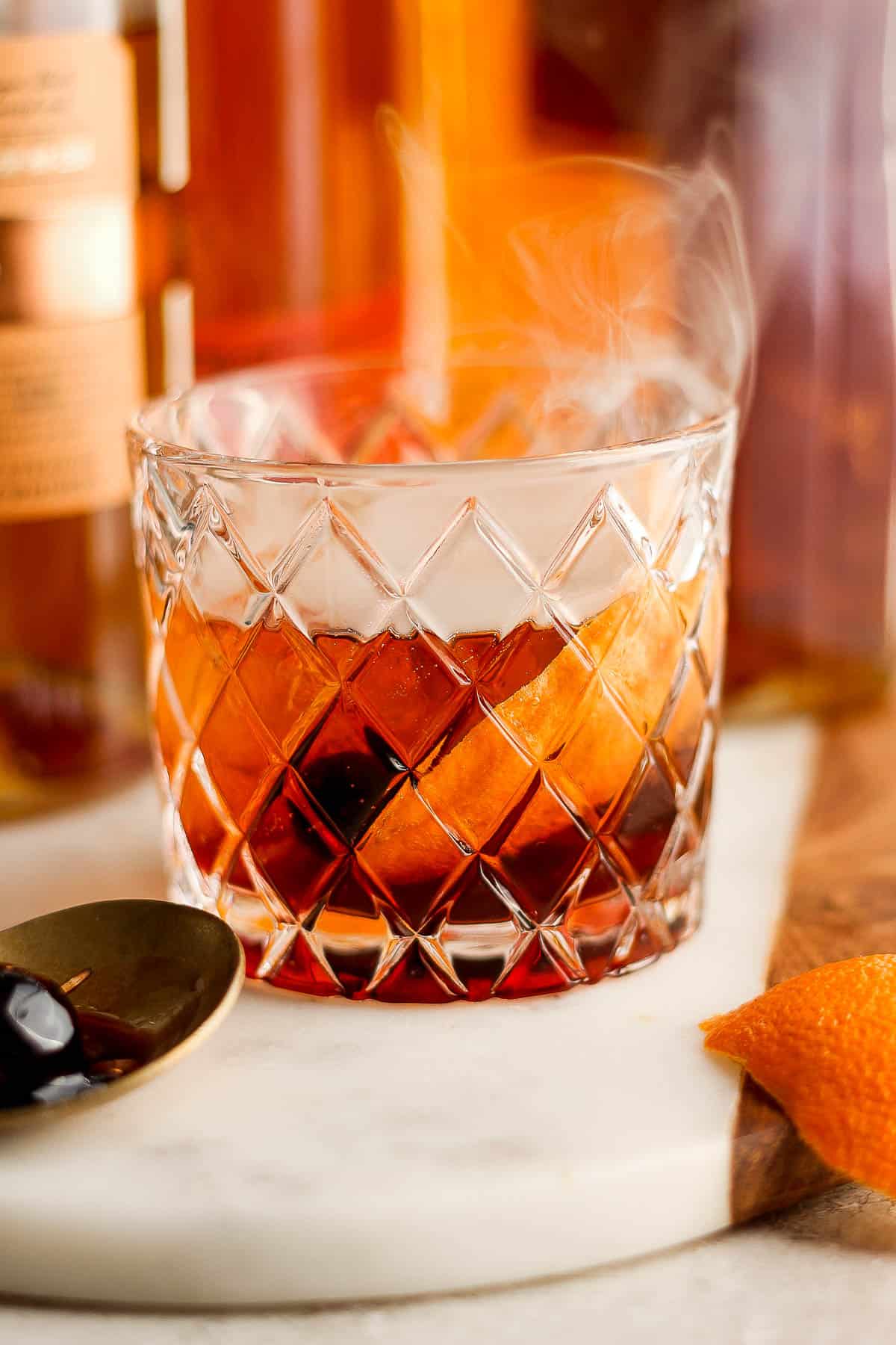 A cocktail glass with a smoked old fashioned.