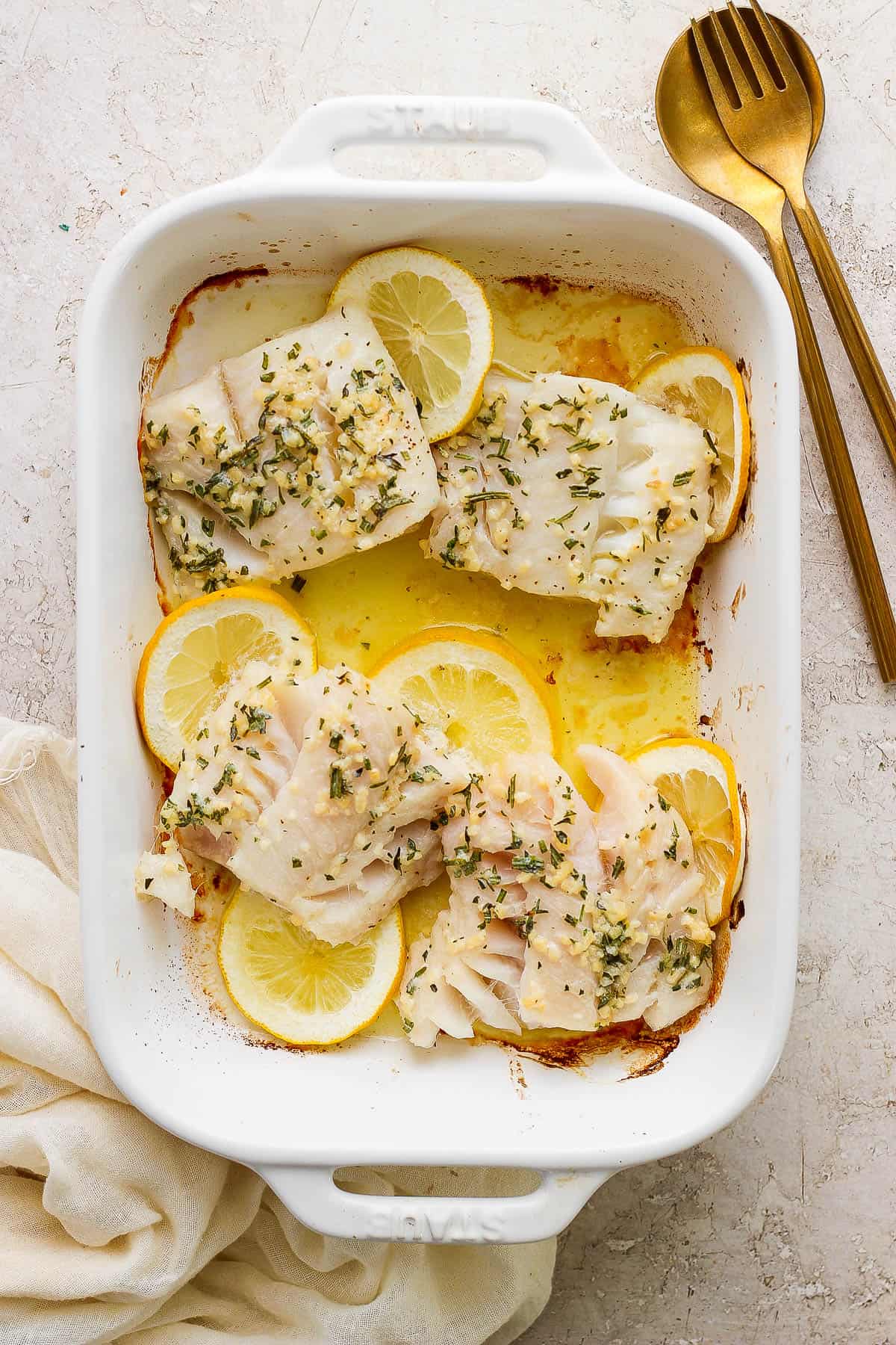 Baked cod in the baking dish after baking in the oven.