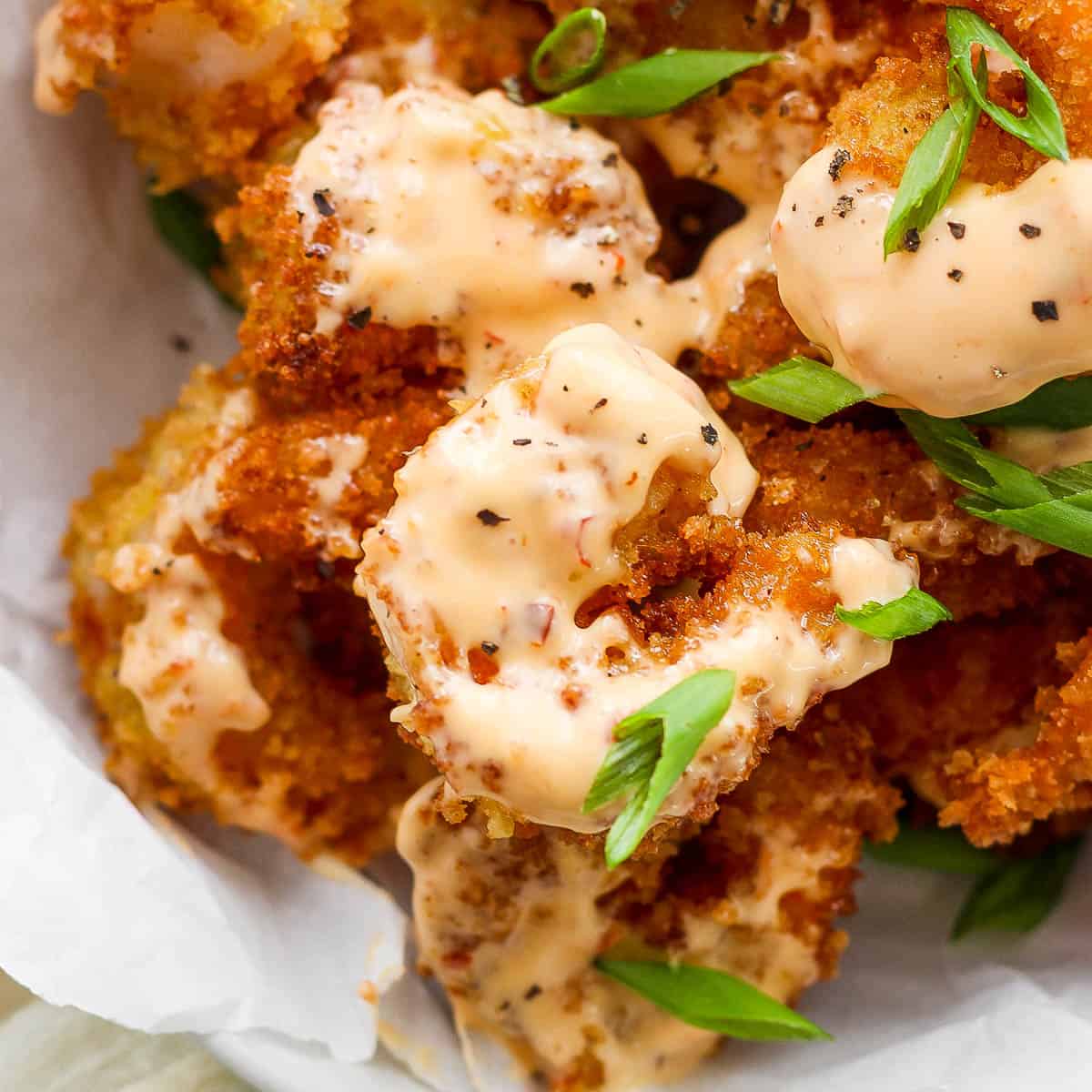 Close up shot of a piece of shrimp with bang bang sauce on it.