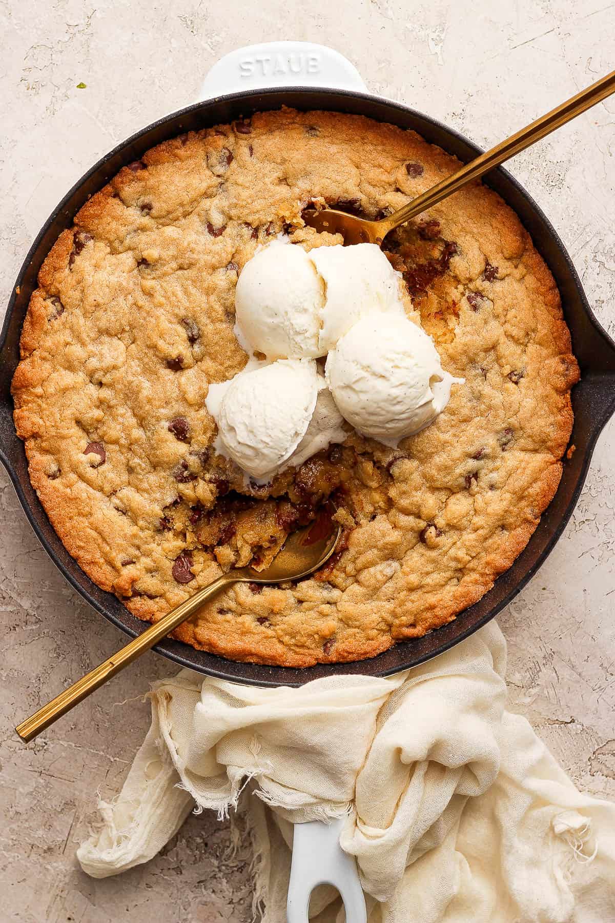 A fully cooked skillet cookie with ice cream on top.