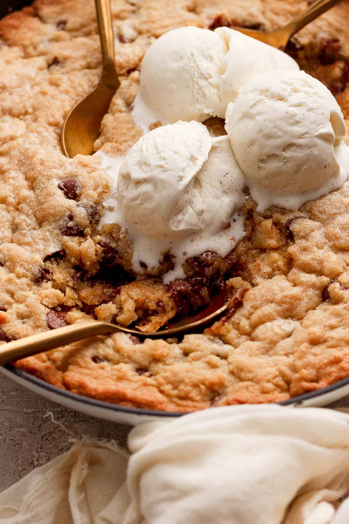 Close-up shot of the melty ice cream on top of the warm skillet cookie.
