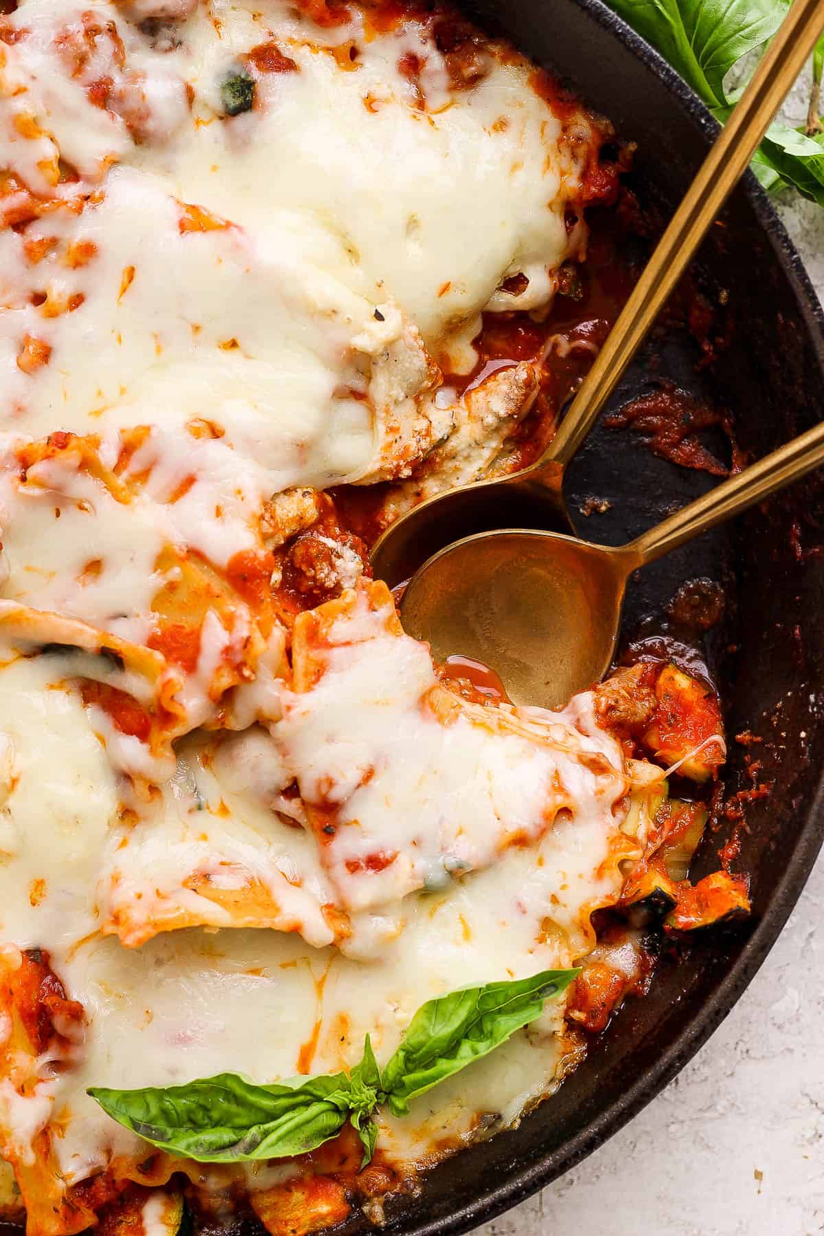 Lazy lasagna in a skillet with two spoons.
