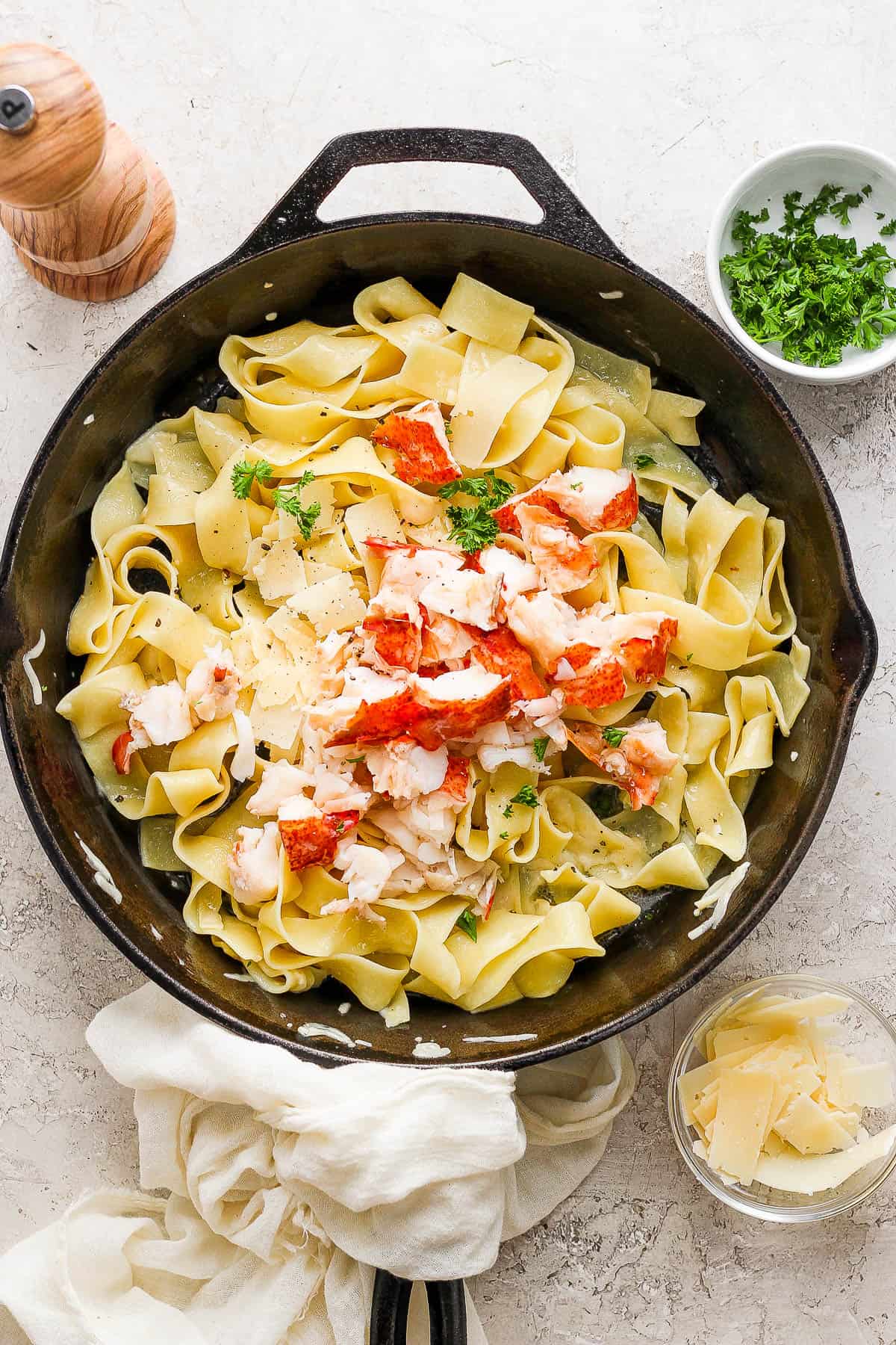 Lobster meat added to the pasta in the skillet.