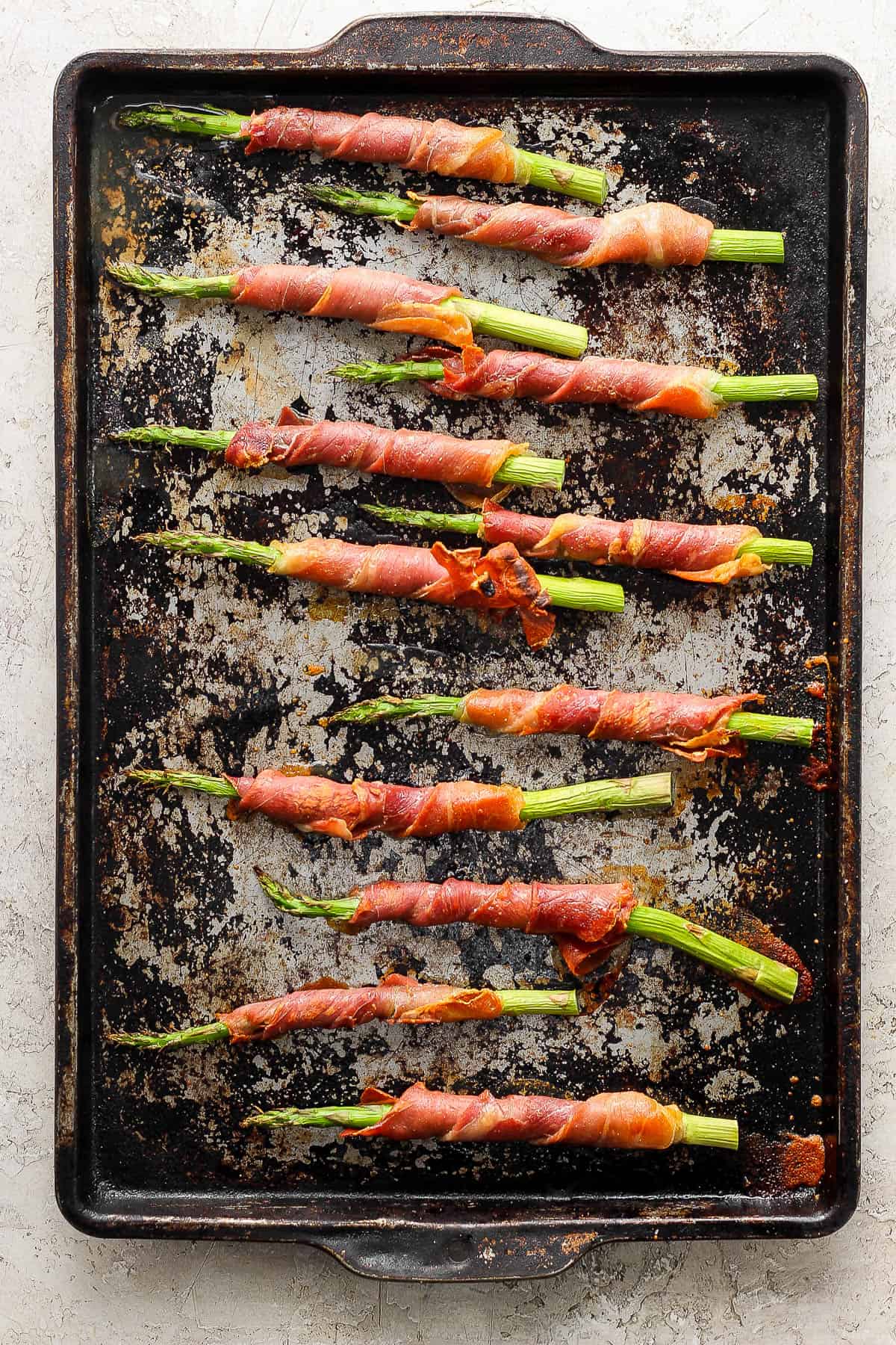 Wrapped asparagus on a sheet pan after baking.