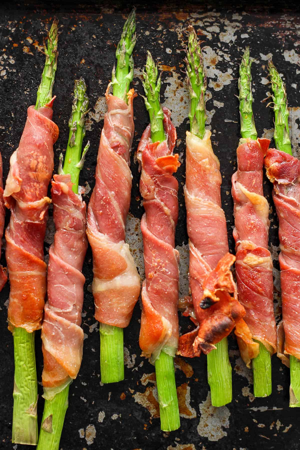 A bunch of prosciutto wrapped asparagus after cooking.