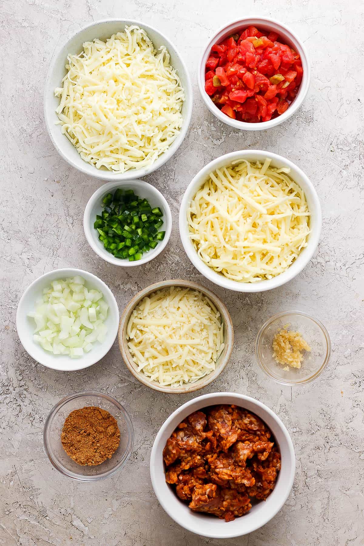 Ingredients for smoked queso in separate bowls.