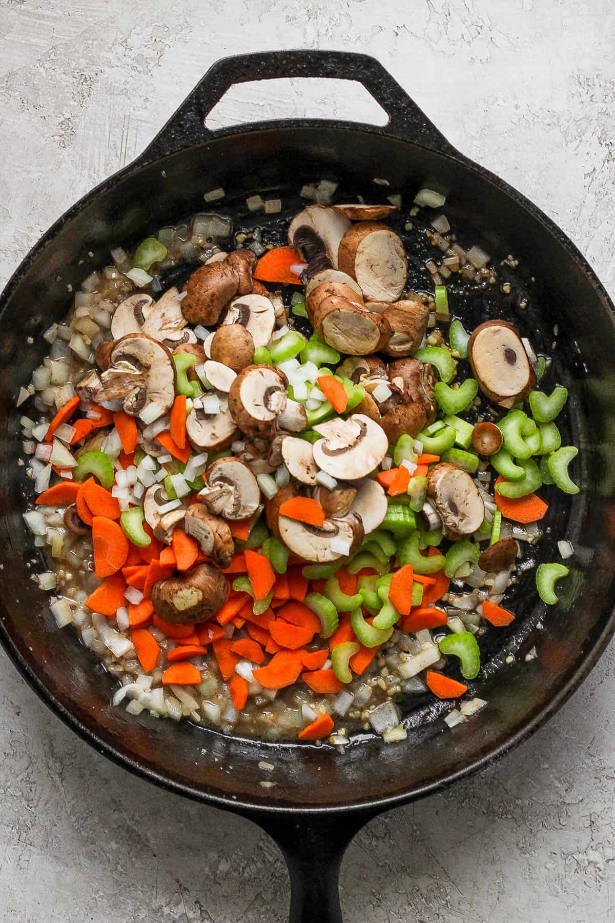 Garlic, butter, celery, carrots, and mushrooms in the cast iron skillet. 