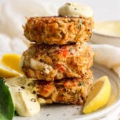Straight on shot of 3 crab cakes stacked with sauce on top.