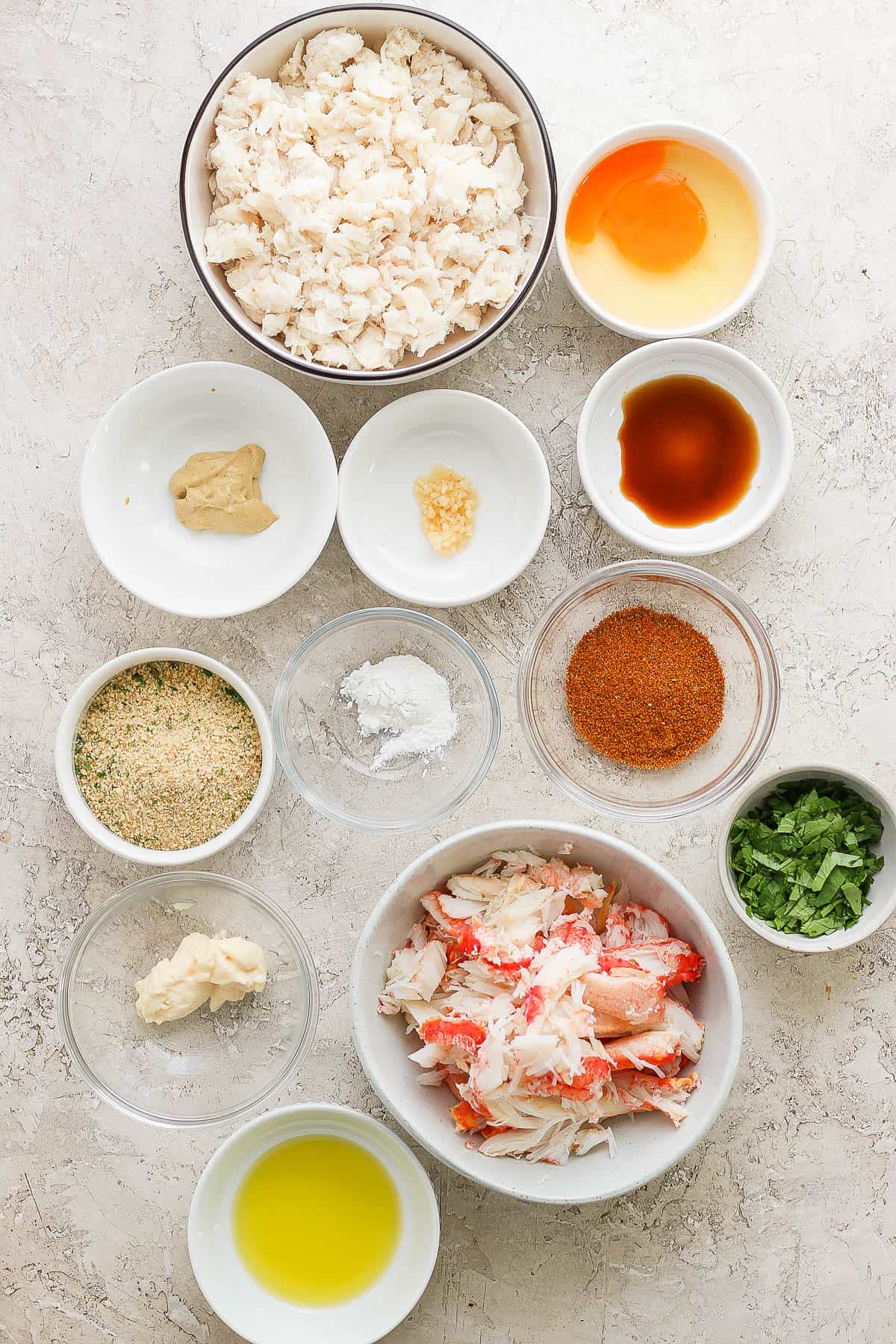 Ingredients for crab cakes in separate bowls.