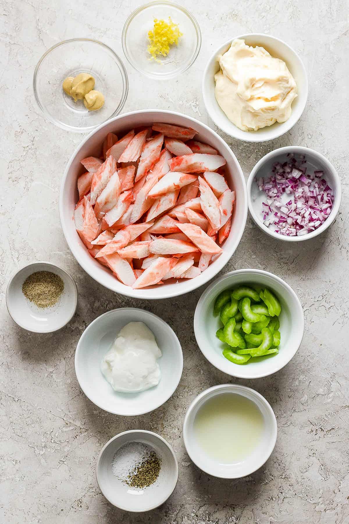 Ingredients for crab salad in separate bowls.
