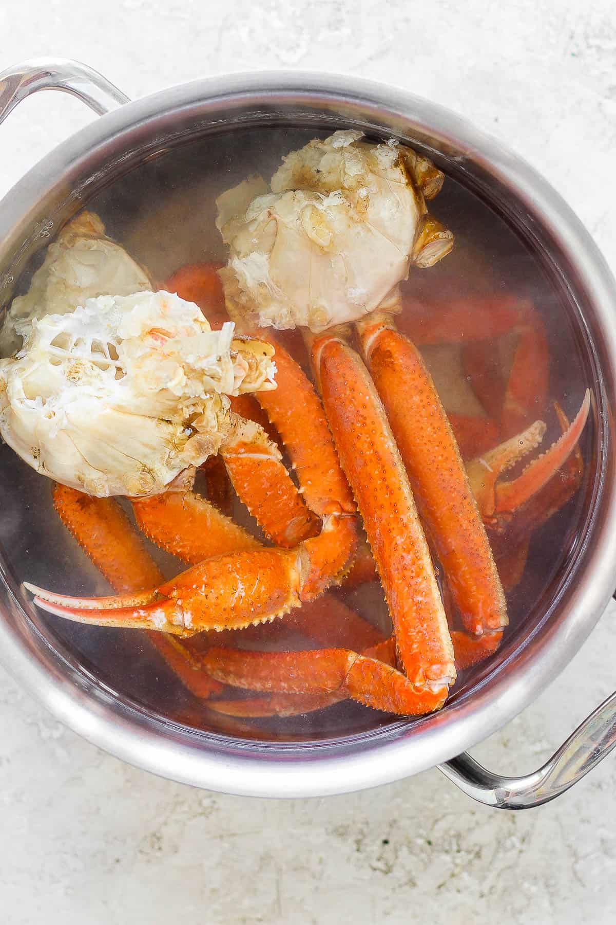 Crab clusters boiling in a pot of water.