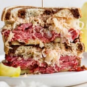 Straight on shot of a reuben sandwich cut in half and then stacked on top of each other.