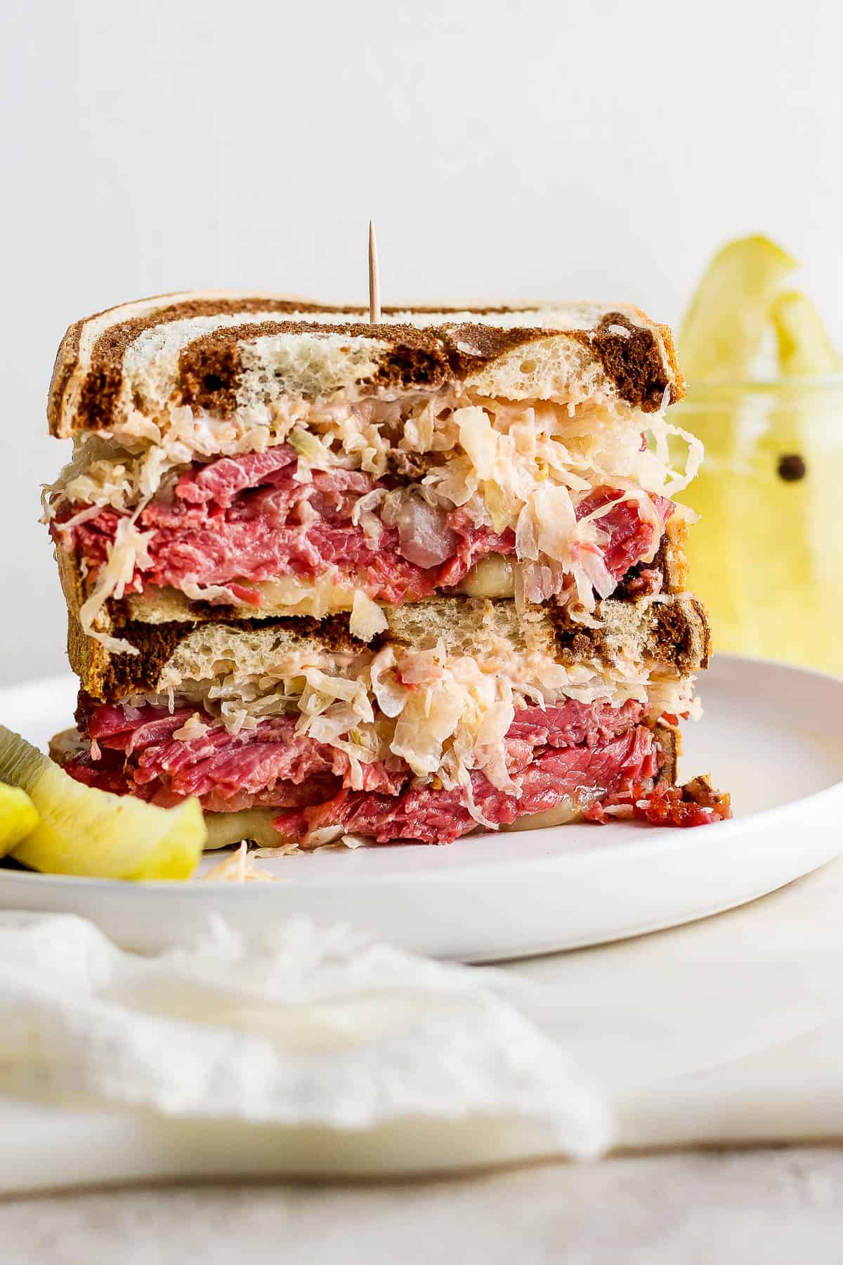 Reuben sandwich cut in half with a toothpick pushed into the sandwich.