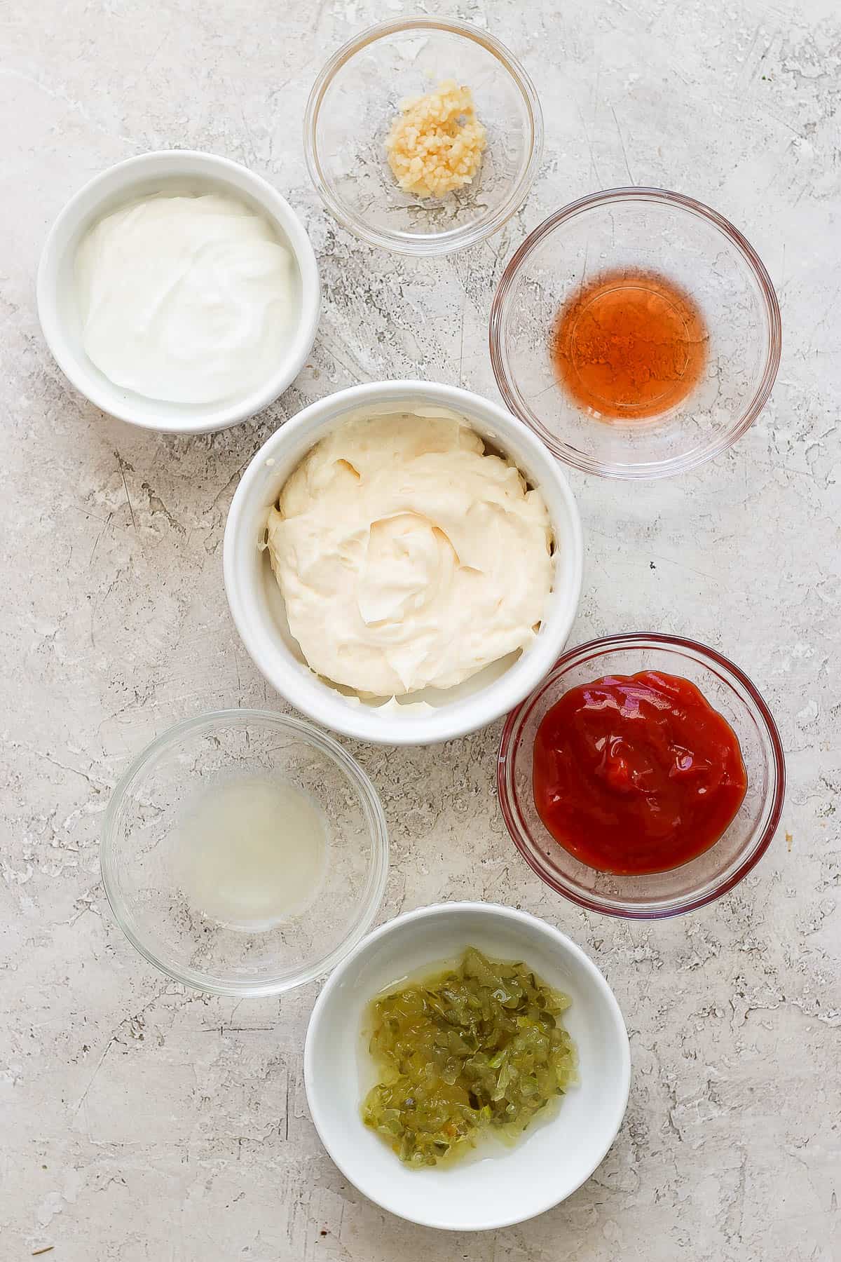 Ingredients for thousand island dressing in separate bowls.