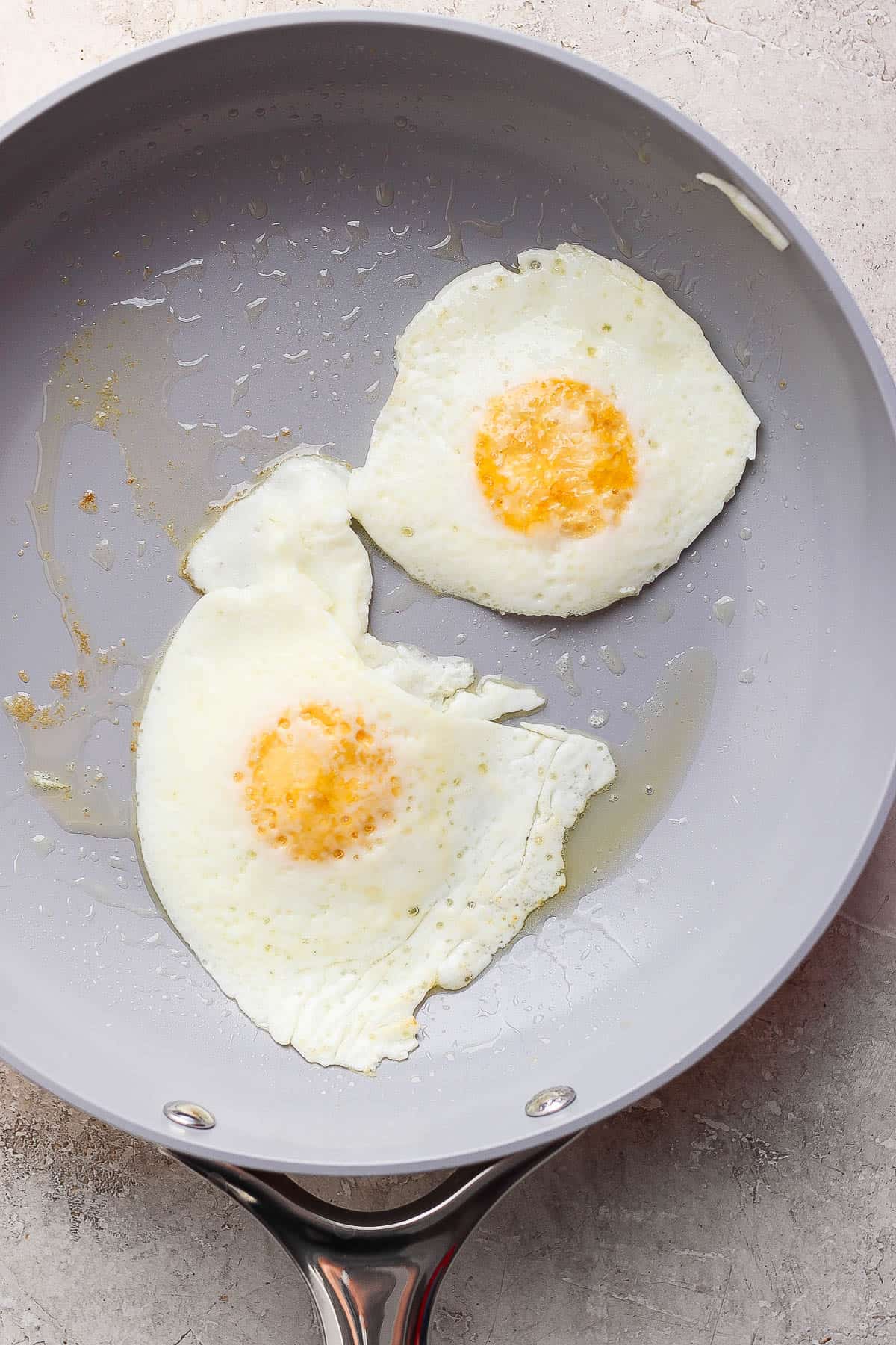Two eggs flipped in the skillet.