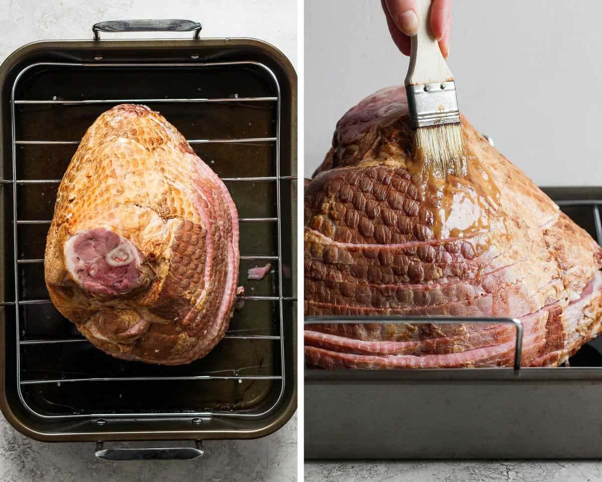 A bone-in half ham on a roasting rack in a roasting pan being brushed with glaze.