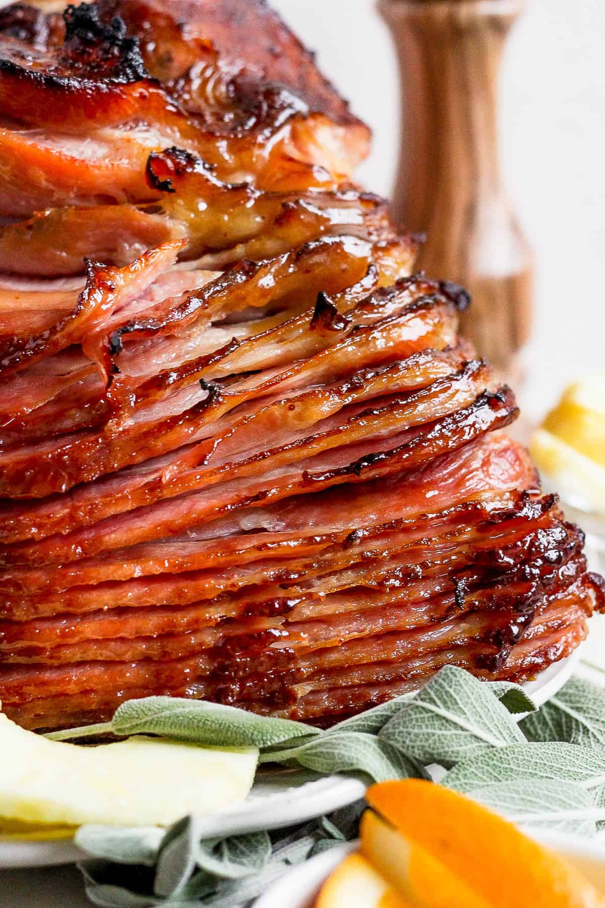 A close up of a cooked spiral ham on a plate.