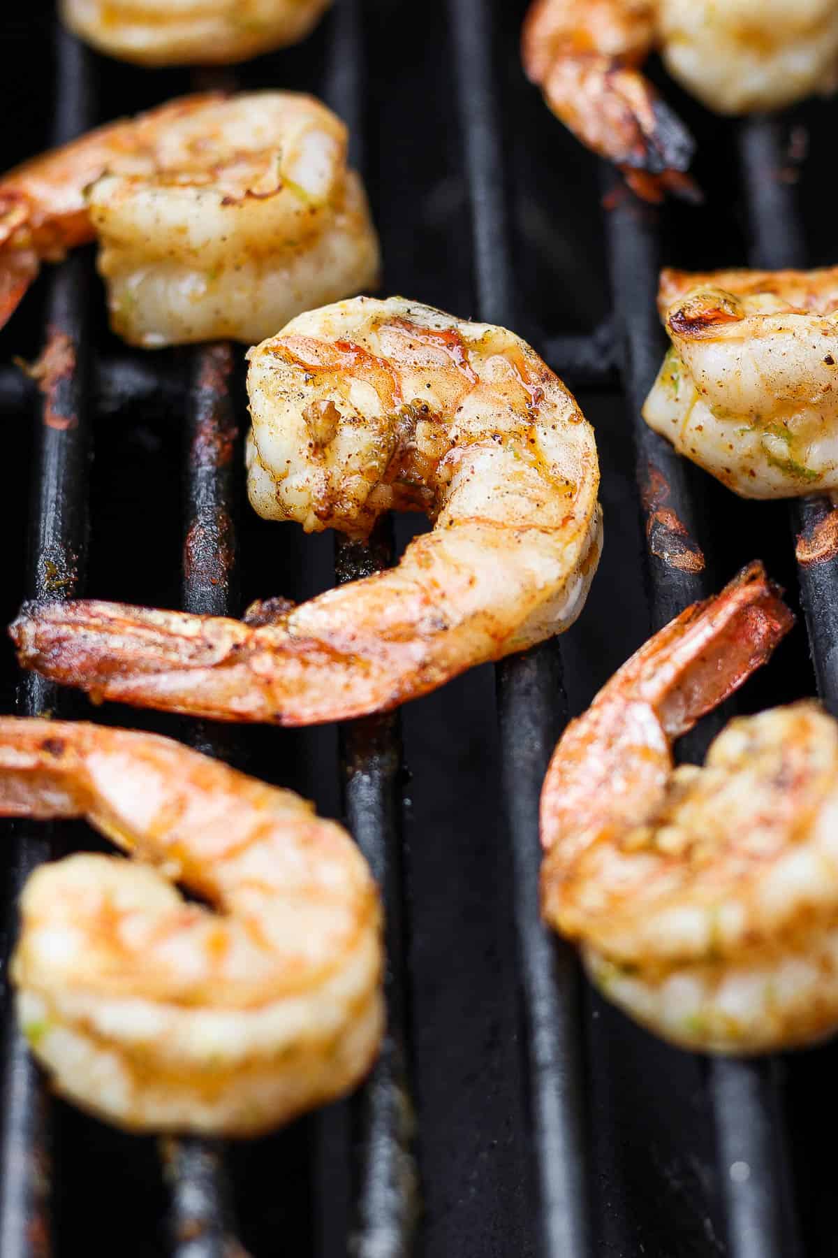Chili lime shrimp cooking on the grill grates.