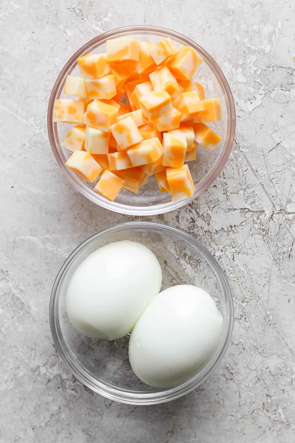 Bowls of cubed cheese and hard boiled eggs.