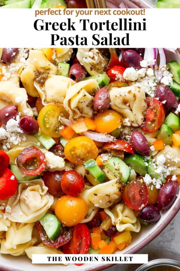 Whole Foods Greek Tortellini Pasta Salad served on a wooden plate with a glass of iced tea