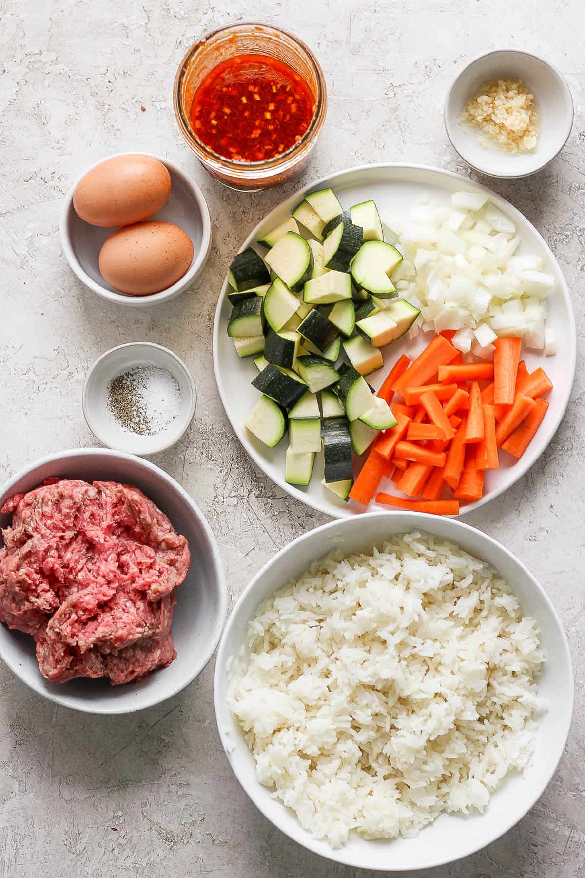 Ingredients for ground beef rice bowls in separate bowls.