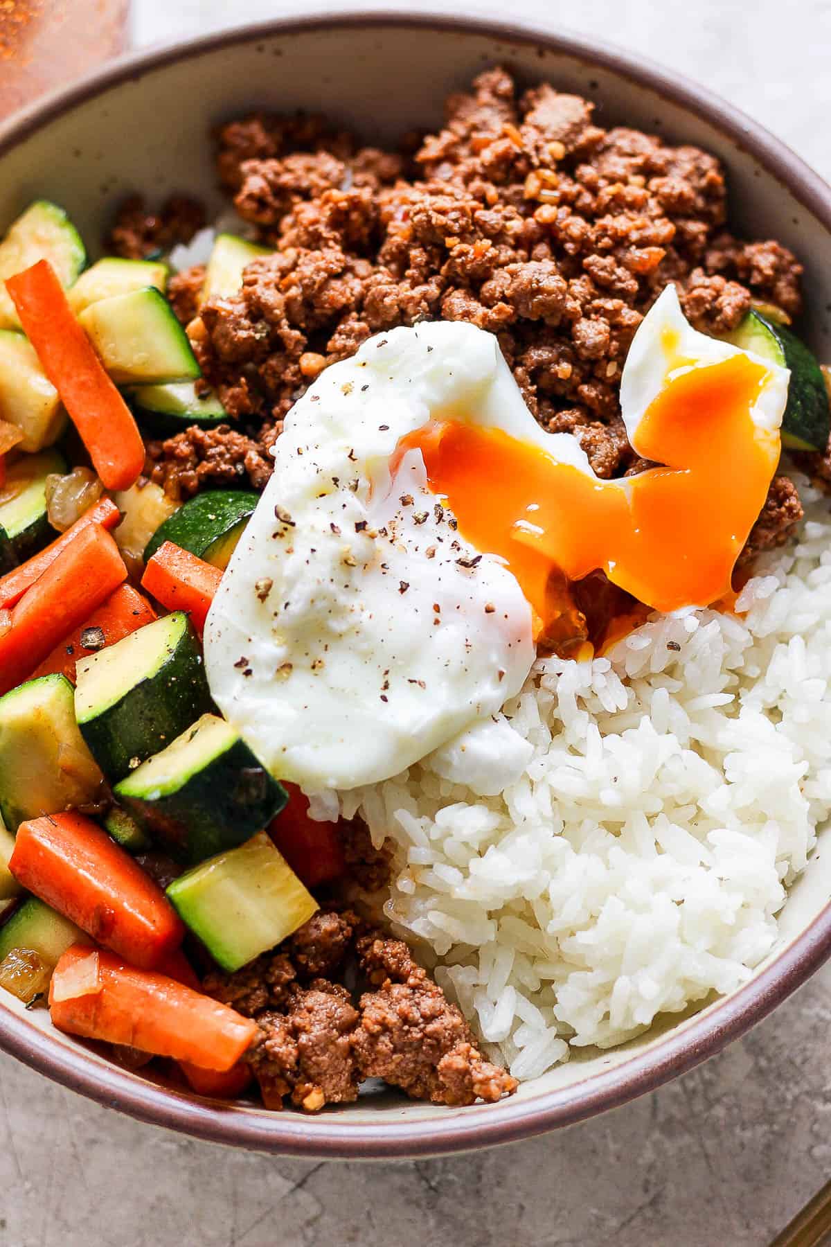 A ground beef bowl with a soft boiled egg on top.