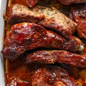 Top down shot and close up of a pan of country style ribs with bbq sauce on top.