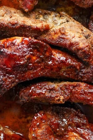 Top down shot and close up of a pan of country style ribs with bbq sauce on top.