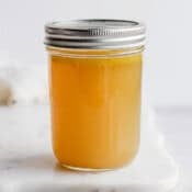 Homemade chicken broth in a mason jar with a lid on top.