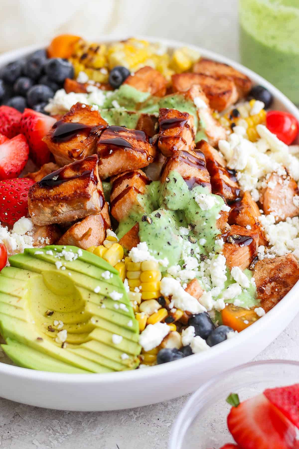 Salmon rice bowl drizzled with balsamic vinegar and basil sauce.