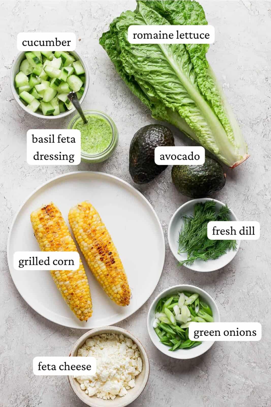 Ingredients for an avocado salad on the counter and in bowls.