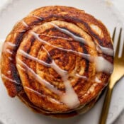 Top down shot of a stack of smashed cinnamon rolls with frosting drizzled over top.