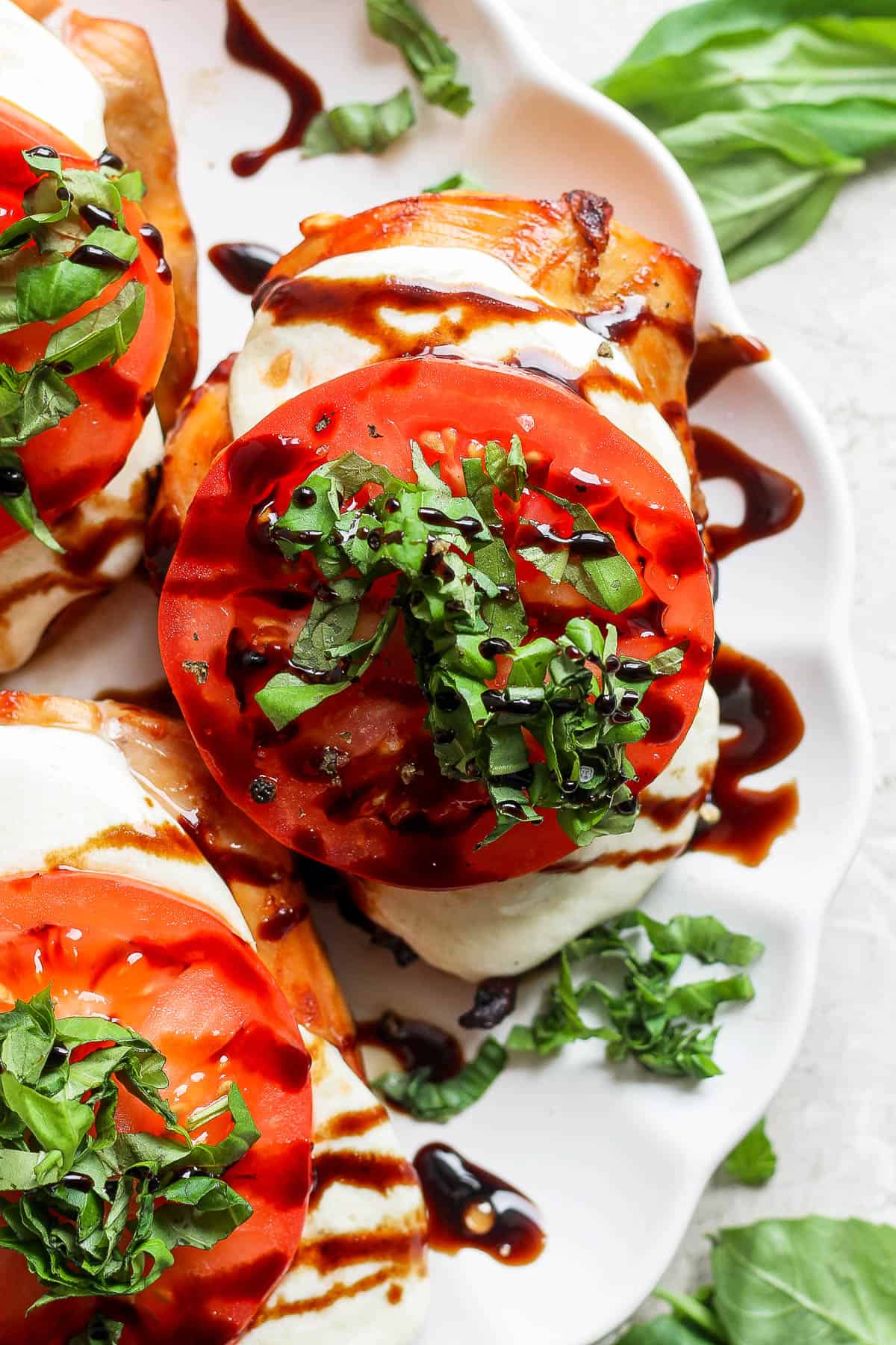 Grilled chicken caprese with basil and balsamic glaze on top.