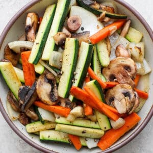 Top down shot of a bowl of hibachi vegetables with salt and pepper on top.
